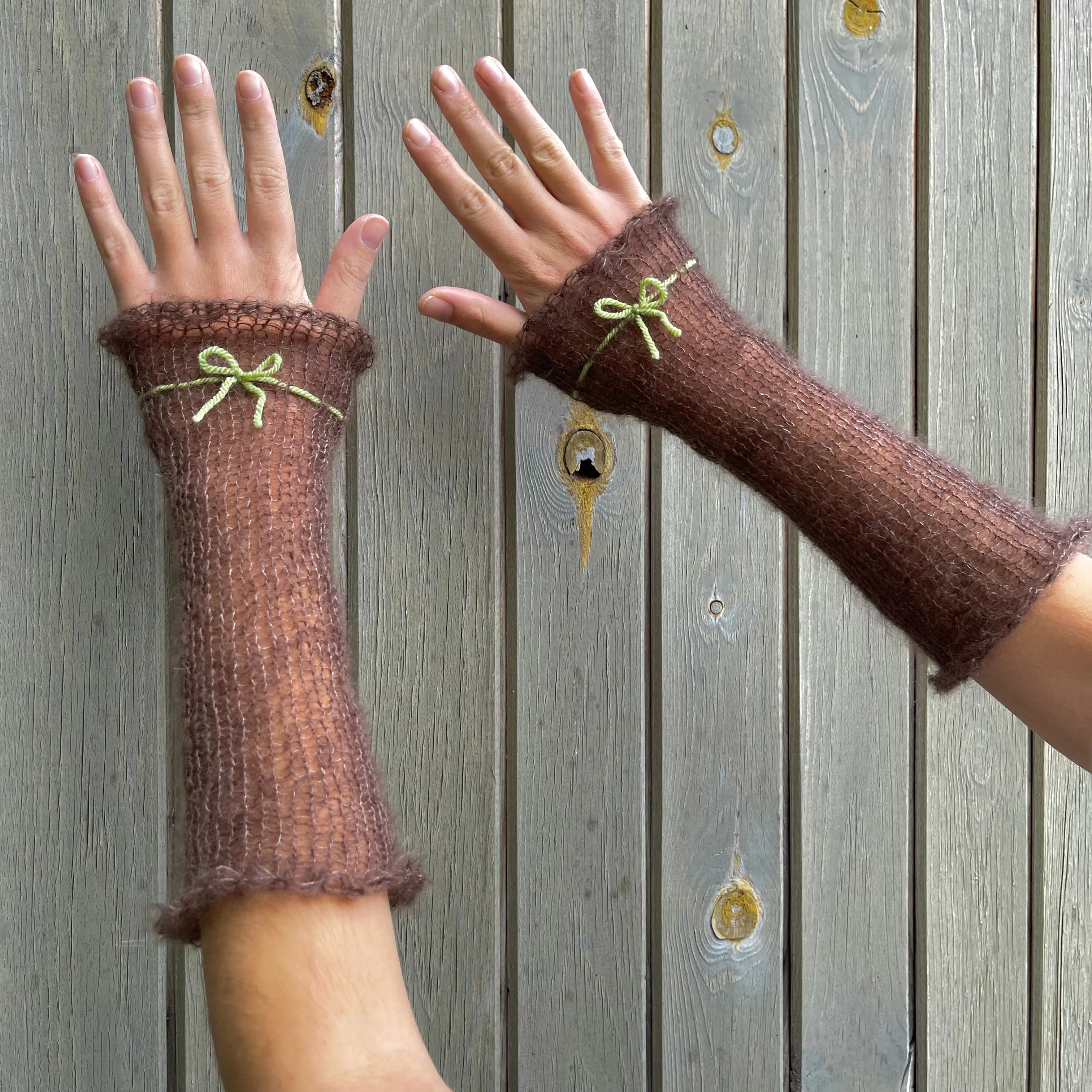 Handmade knitted mohair hand warmers in brown with olive green bow